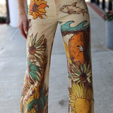 Hand-painted jeans with sunflower and wave designs on a concrete floor.