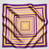 A square silk scarf featuring a geometric pattern of concentric squares in purple and yellow, displayed flat with soft folds on a white background.