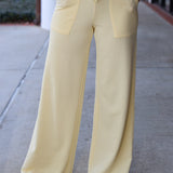 Person wearing light yellow pants on a sidewalk