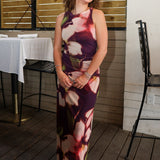 Rylen Midi Dress by Steve Madden is sleeveless, floor-length halter dress with a dark purple base and a large floral print in pink, red, and white. 
