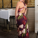 Rylen Midi Dress by Steve Madden is sleeveless, floor-length halter dress with a dark purple base and a large floral print in pink, red, and white. 