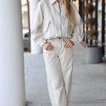 Woman wearing a striped pants 
outfit with sunglasses in an urban setting