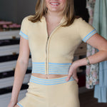Woman wearing a yellow and blue knit outfit in a store setting