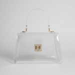 A clear vinyl handbag with a semi-translucent handle, gold-tone hardware, and a small gold clasp on the front, set against a dark gray background.
