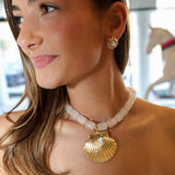 Woman wearing a necklace and earrings with a blurred background