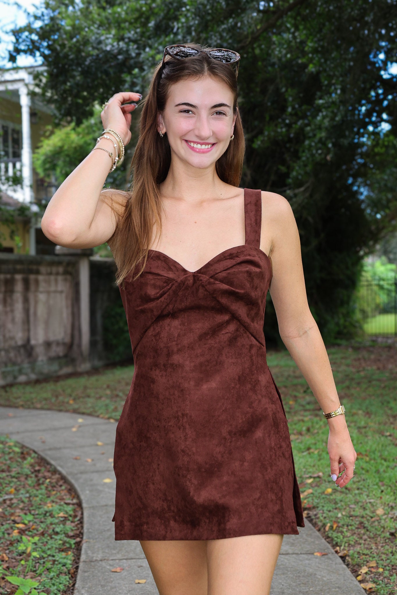 A woman wearing the Soho Romper by Amanda Uprichard. a brown faux suede mini dress with a sweetheart neckline.