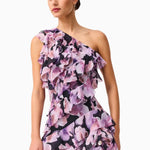 Woman wearing a Solene purple floral one-shoulder dress on a white background