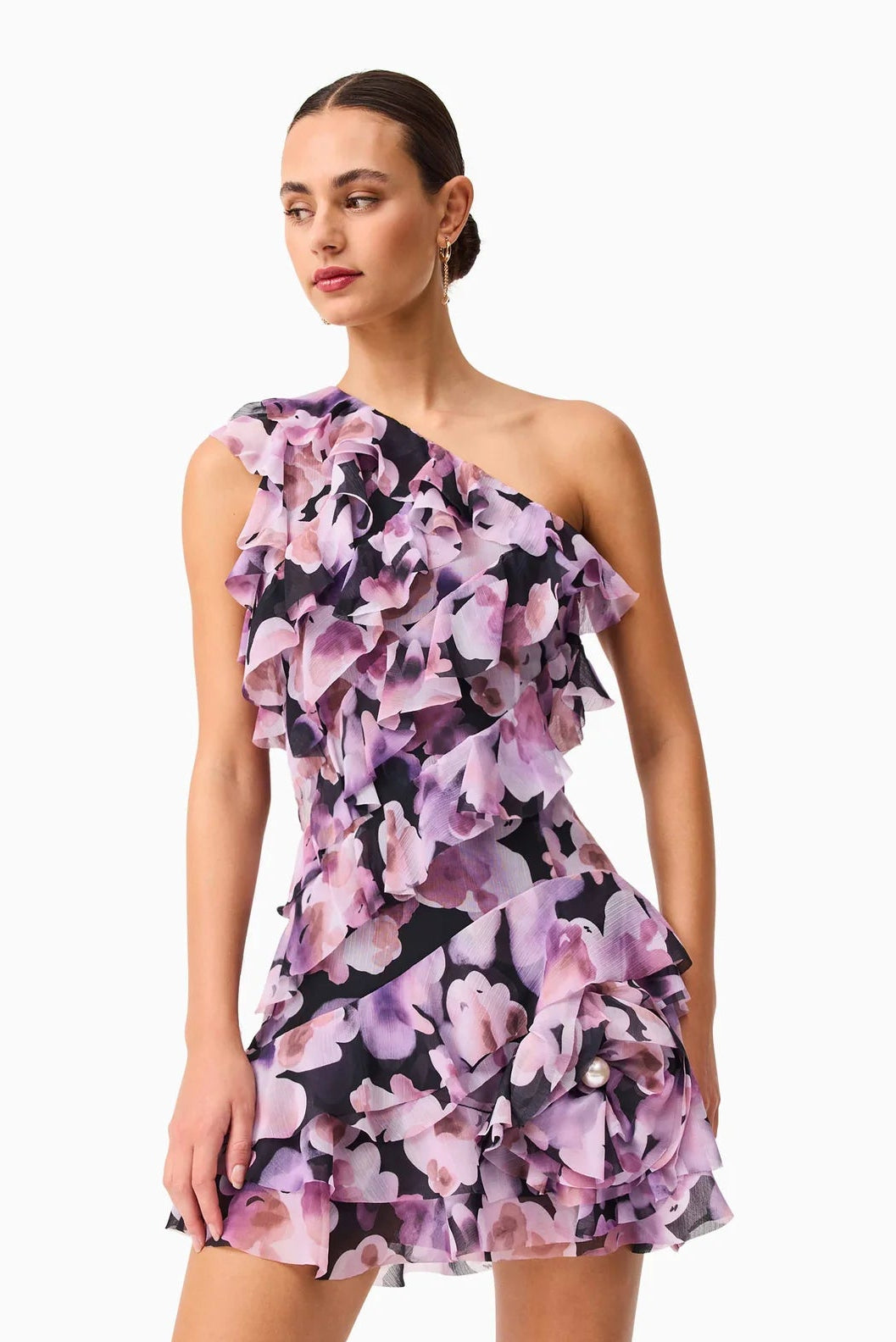 Woman wearing a Solene purple floral one-shoulder dress on a white background