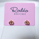 A pair of tiny gold hoop earrings with clear rhinestone small hoop, displayed on a pink card labeled 'Rodéo BOUTIQUE' against a light gray background.