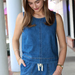Woman wearing a blue denim short matching set standing outdoors.