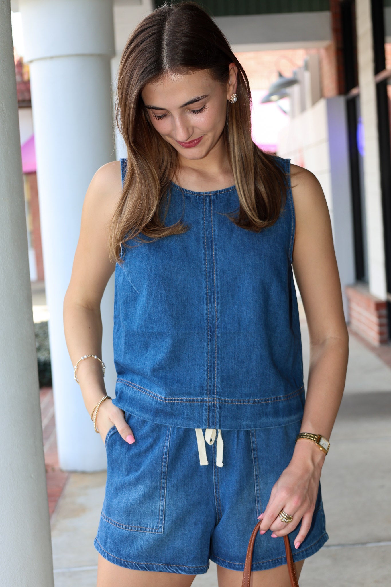 Woman wearing a blue denim short matching set standing outdoors.