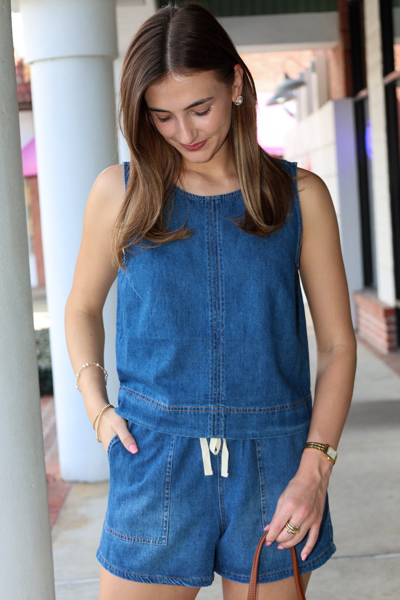 Woman wearing a blue denim short matching set standing outdoors.
