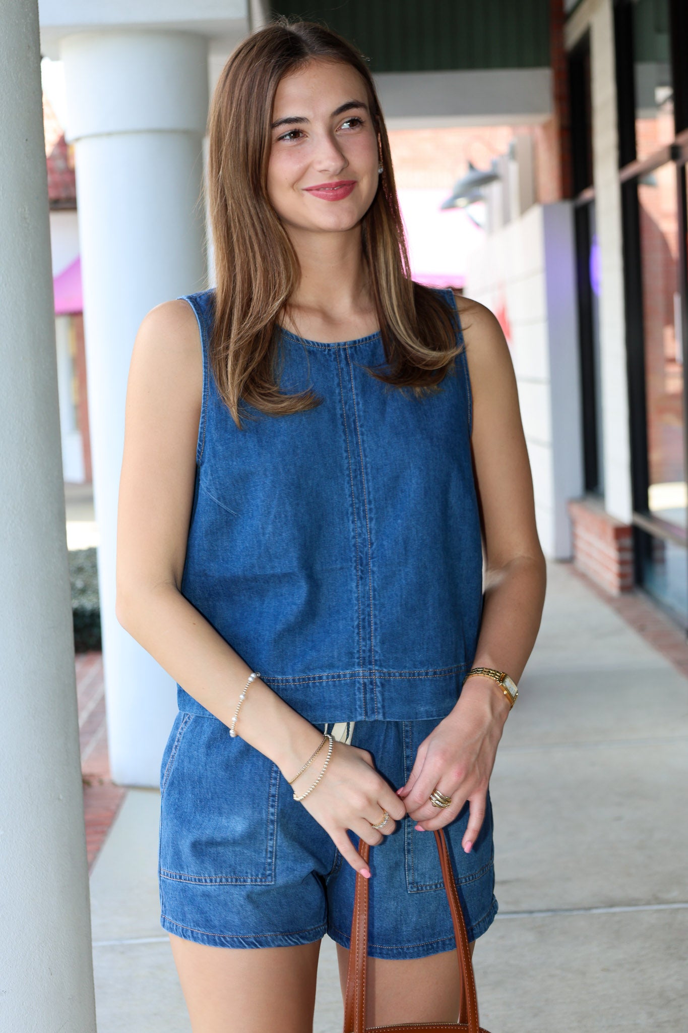 Woman wearing a blue denim outfit standing outdoors.