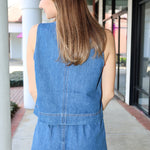 Woman wearing a denim short matching set standing outside a building.