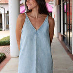 Woman wearing a light denim Tavi dress by Pistola.