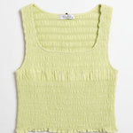 Light green smocked sleeveless top against a neutral background