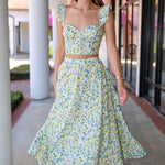 Woman wearing a green skirt set standing outdoors.