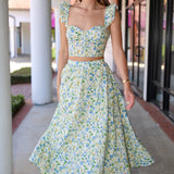 Woman wearing a green skirt set standing outdoors.