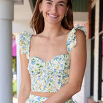Woman wearing a green skirt set standing outdoors.