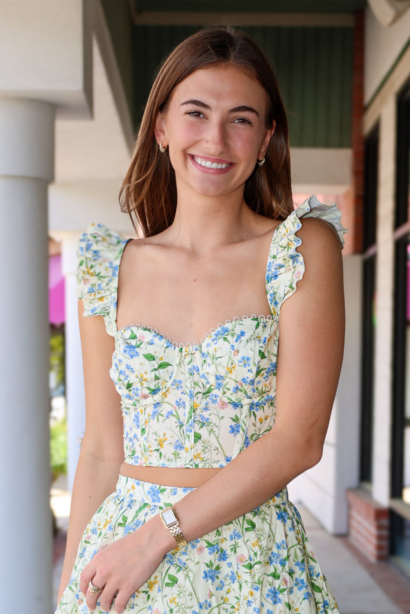 Woman wearing a green skirt set standing outdoors.