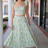 Woman wearing a green skirt set standing outdoors.
