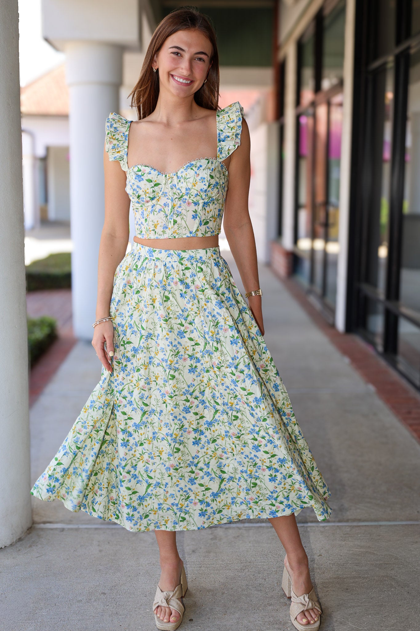 Woman wearing a green skirt set standing outdoors.