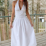 Woman wearing a white midi dress with plunging v neck