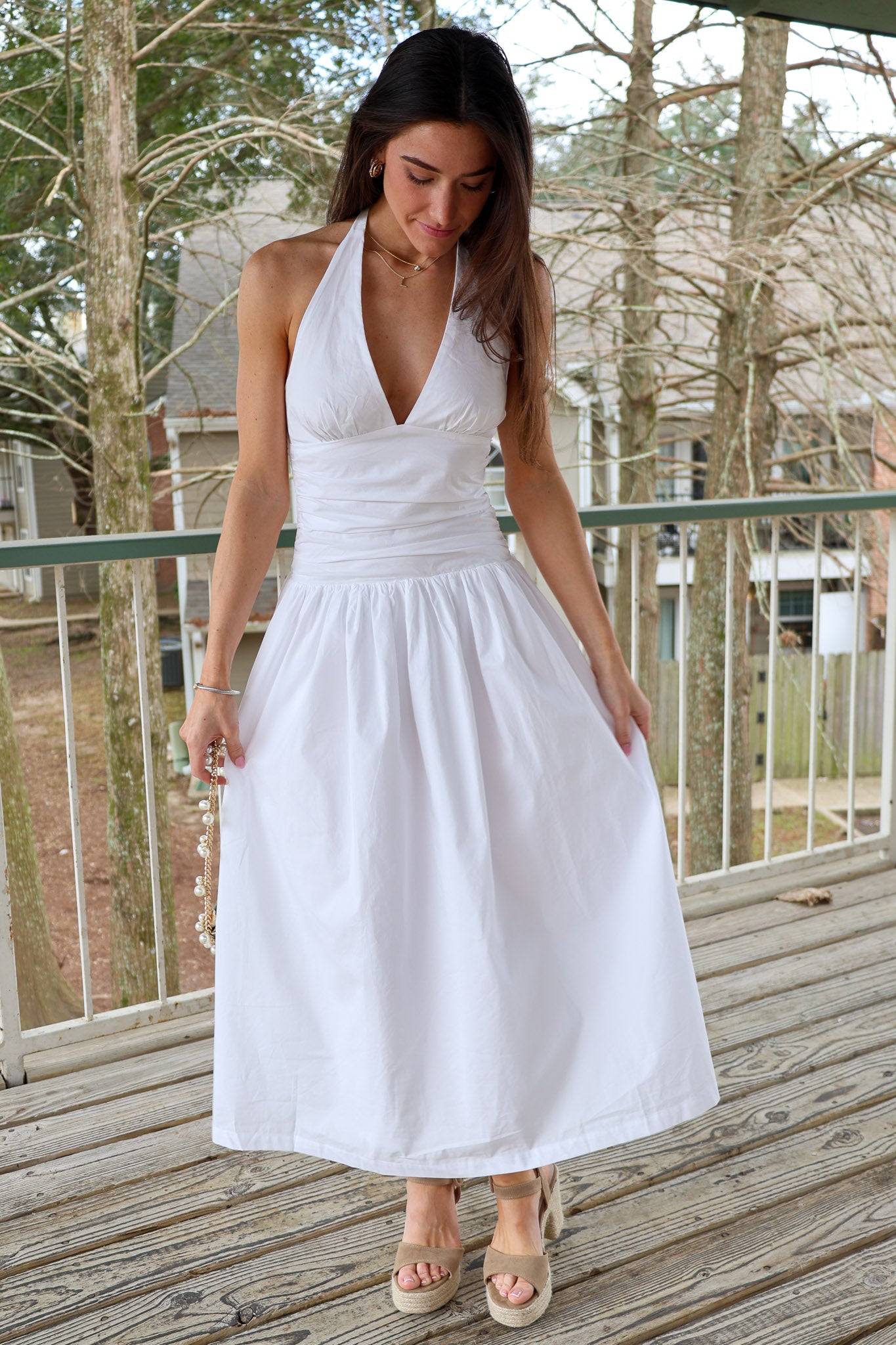 Woman wearing a white midi dress with plunging v neck