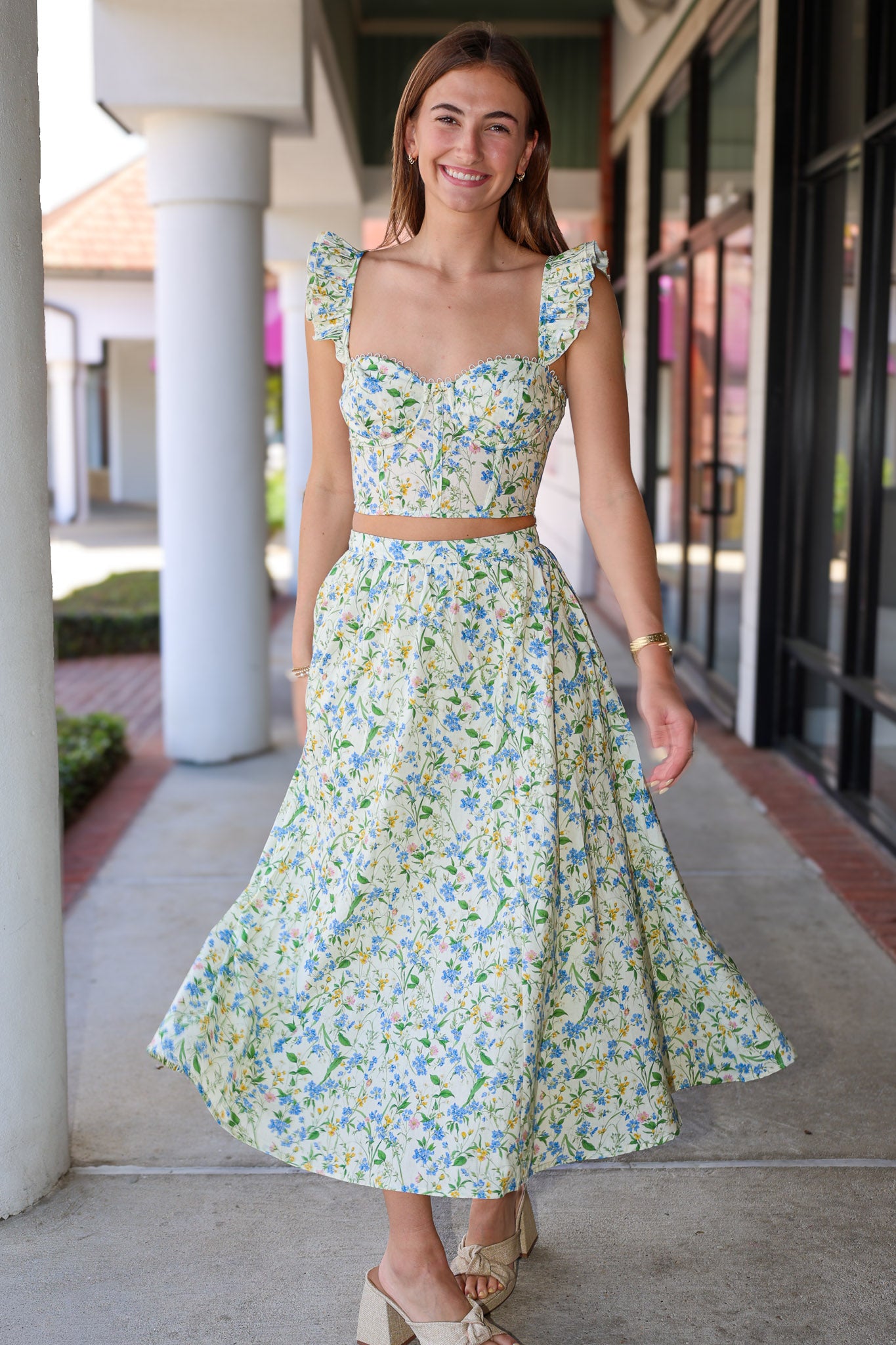Woman wearing a floral skirt set standing outdoors.