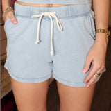 Light blue shorts with a drawstring worn by a person indoors.