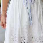 White eyelet skirt with blue drawstring and a blurred background